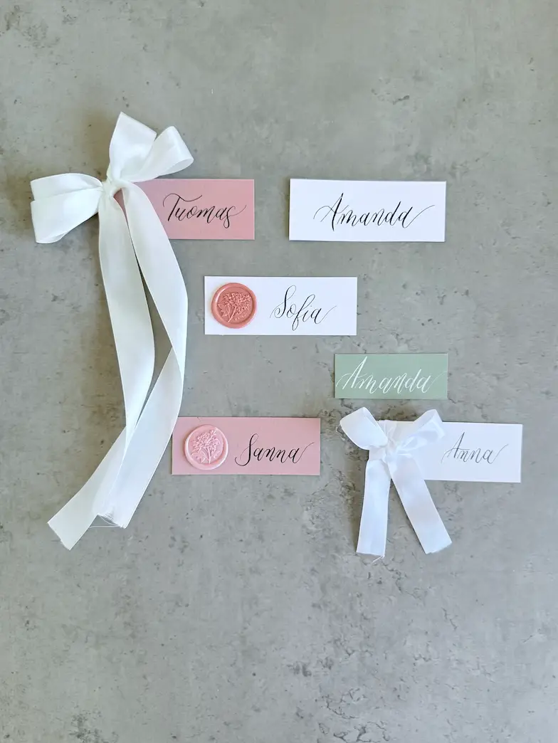 Paperituotteet. Paikkakortit kalligrafialla ja rusetilla tai vahasinetillä.